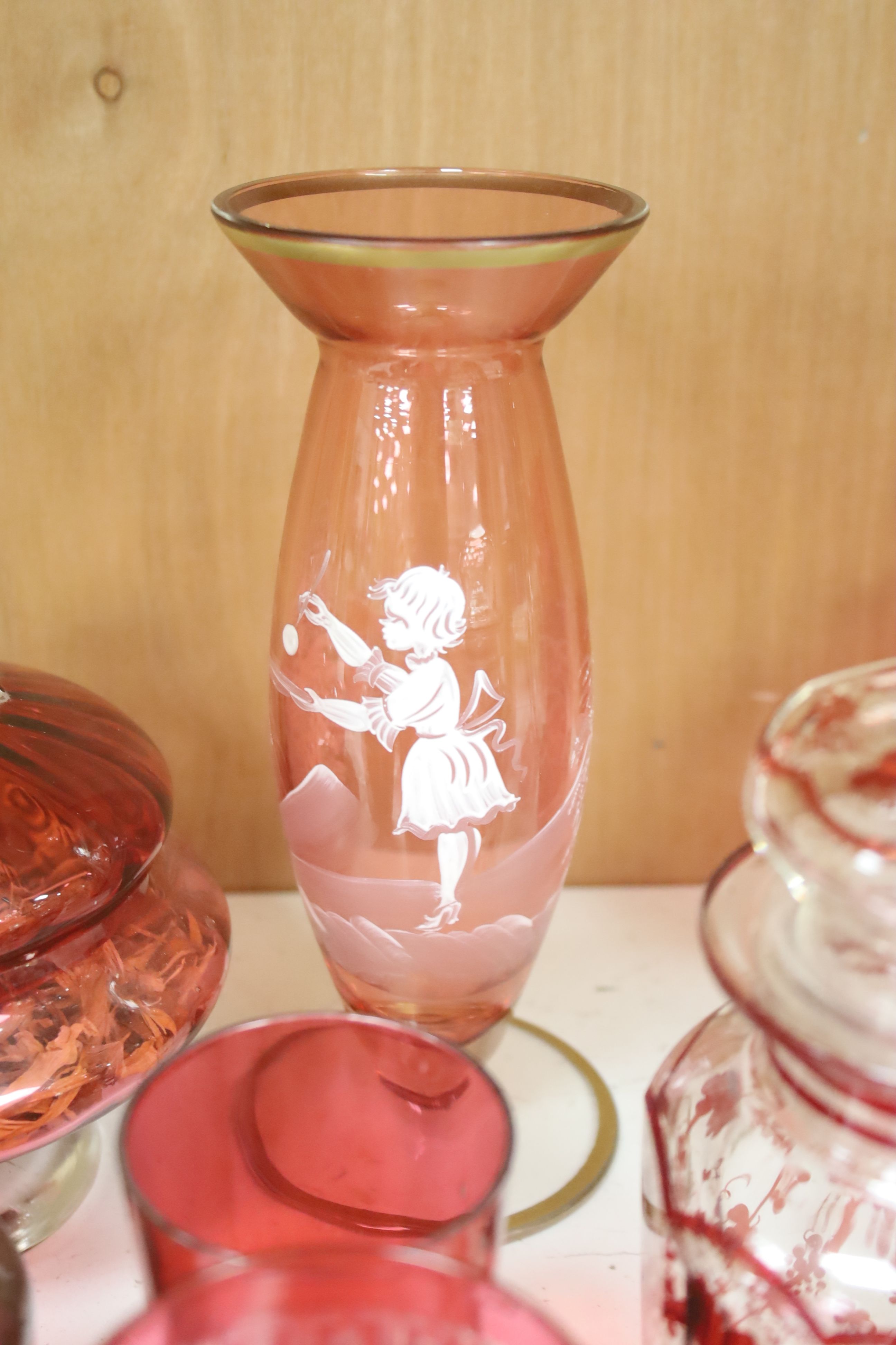 A collection of cranberry and ruby glassware including a 'Mary Gregory' vase